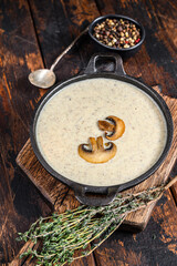 Mushroom cream soup with herbs and spices. Dark Wooden background. Top view