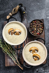 Obraz na płótnie Canvas Champignon Mushroom cream soup with herbs in a bowl. Black background. Top view