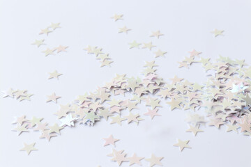 Light Background with stars confetti. Sparkles on the light trendy background. Close-up. The festive backdrop for your projects.