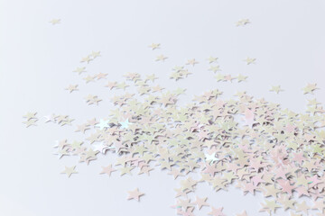 Holiday concept. Light background with stars confetti. Close-up. The festive backdrop for your projects.