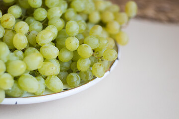 Close-up. Green grape. Beautiful white plate with fresh grape on the table. Home concept.