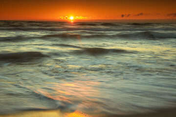 Baltic Sea in sunrise. Moving waves splashing in the coast