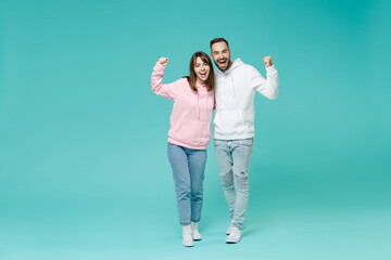 Full length of happy young couple two friends man woman 20s wearing white pink casual hoodie doing...