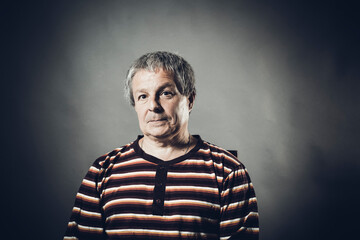 Solid middle aged man studio portrait on grey background.
