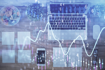 Stock market graph and top view computer on the table background. Multi exposure. Concept of financial education.