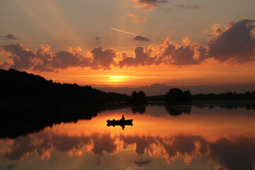 Epic sunset over the lake, fisherman in harmony.