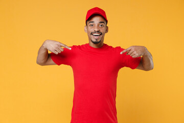 Naklejka premium Delivery employee african man 20s in red cap blank print t-shirt uniform workwear work courier dealer service during quarantine coronavirus covid-19 virus concept isolated on yellow background studio.