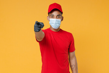 Fototapeta na wymiar Delivery employee african man in red cap blank print t-shirt face mask gloves uniform work courier dealer service on quarantine coronavirus covid-19 virus concept isolated on yellow background studio.