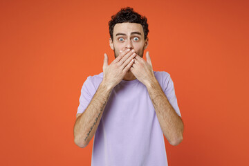 Shocked worried scared young bearded man 20s wearing basic casual violet t-shirt standing covering...
