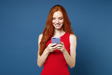 Smiling cheerful pretty young redhead woman 20s wearing bright red elegant evening dress standing...