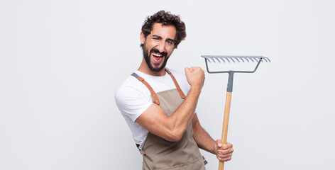 young man feeling happy, satisfied and powerful, flexing fit and muscular biceps, looking strong...