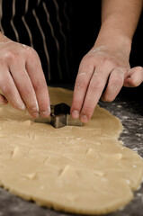 manos cortando galletas de navidad en forma de estrella 