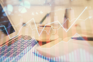 Double exposure of financial chart drawing and desktop with coffee and items on table background. Concept of forex market trading