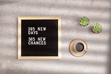 365 new days, 365 new chances. Letter board with motivational quote on grey concrete background with coffee cup. New year resolutions and goal setting, self improvement