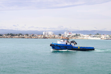 Fototapeta premium Boat in blue sea with blue sky and view of the beach on background, Vinaros, Valencia, Spain