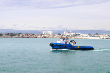 Boat in blue sea with blue sky and view of the beach on background, Vinaros, Valencia, Spain