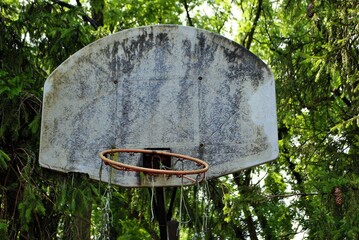 very old abandoned basketball hoop that is falling apart