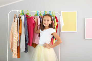 Little cute girl chooses clothes in dressing room