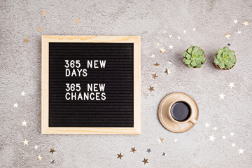 365 new days, 365 new chances. Letter board with motivational quote on grey concrete background with coffee cup. New year resolutions and goal setting, self improvement