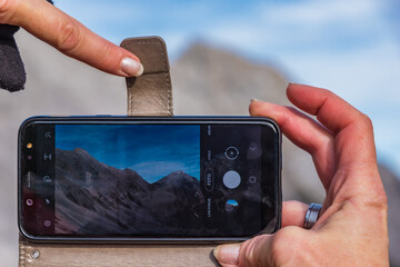 Finger am Smartphones mit Landschaftsfoto