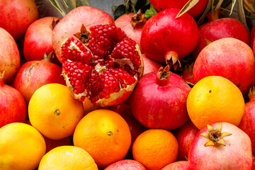 Naklejka na ściany i meble Heap of fresh pomegranates and oranges for sale in market