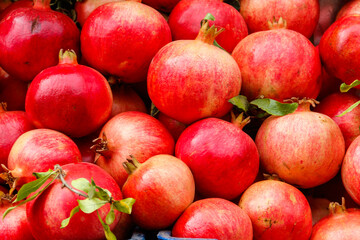 Heap of fresh pomegranates for sale in market. Background of pomegranate fruits