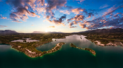 Beautiful Panoramic View of Scenic Lake, Islands and Forest in Canadian Nature. Colorful Sunset Sky. Aerial Done Shot taken near Klondike Highway. Lewes Lake, South of Whitehorse, Yukon, Canada.