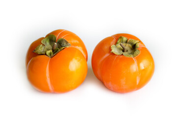 Ripe persimmon isolated on light background, seasonal winter fruit