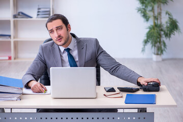 Young male employee unhappy with excessive work in the office