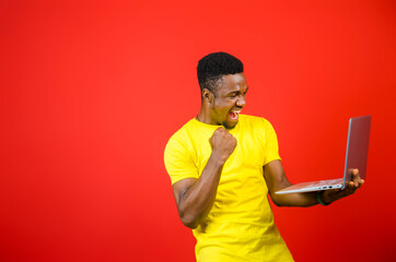 a young handsome african man feeling excited about what he saw on his cellphone