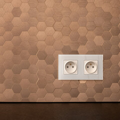 White sockets in copper wall, close-up