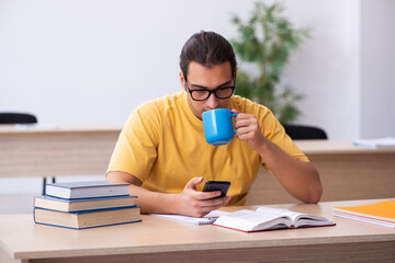 Young male student having break during exam preparation