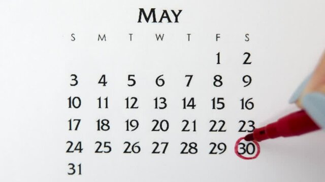 Female hand circle day in calendar date with a red marker. Business Basics Wall Calendar Planner and Organizer. May 30th