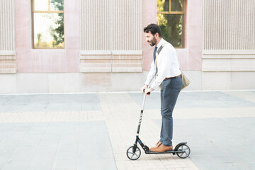 Hispanic male worker riding an eco-friendly scooter