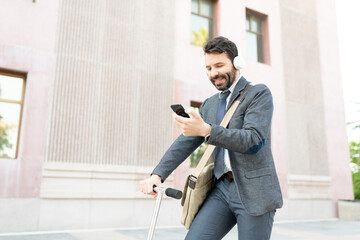 Happy male worker listening to music while commuting to work in a scooter