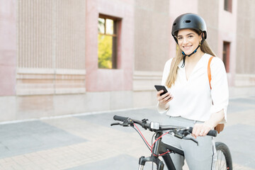 Businesswoman using her smartphone before starting her bike commute