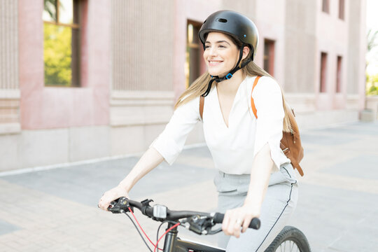 Happy businesswoman riding a bike to work