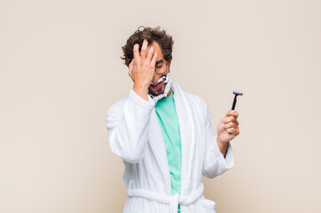 young man laughing and slapping forehead like saying d’oh! I forgot or that was a stupid mistake