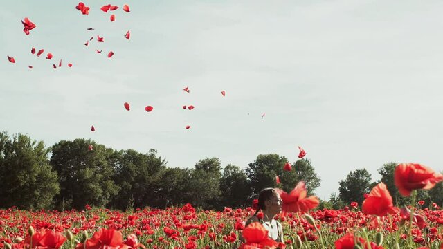 Outdoor portrait of a fashion vogue woman. Girl in a field with wildflowers poppy petals. Provence, freedom on nature concept. Trend model on spring meadow. Young romantic Spring Style.