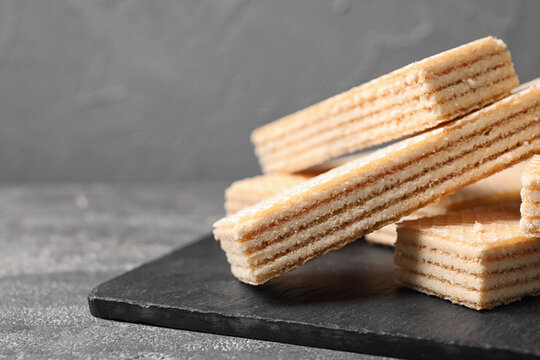 Delicious cream wafers on grey table, closeup. Space for text