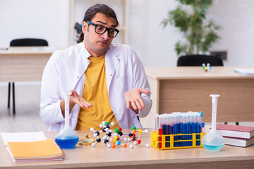 Young male chemist teacher in the classroom