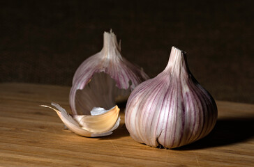 garlic bulb, clove and skin on a wooden board 