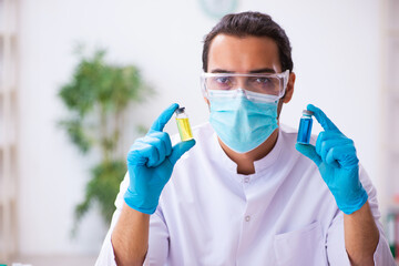 Obraz na płótnie Canvas Young male chemist working in the lab