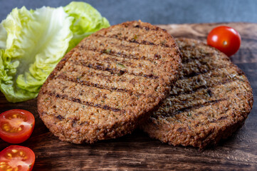 Making tasty vegetarian hamburgers from plant based grilled burgers, fresh bakes buns and organic vegetables