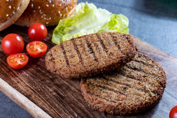 Making tasty vegetarian hamburgers from plant based grilled burgers, fresh bakes buns and organic vegetables