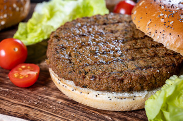 Making tasty vegetarian hamburgers from plant based grilled burgers, fresh bakes buns and organic vegetables