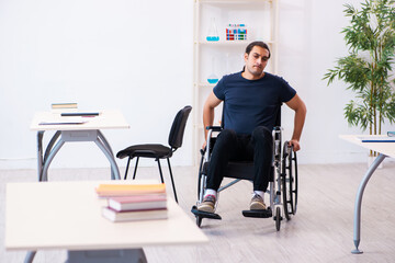 Young male student in wheel-chair preparing for exams