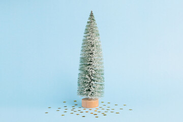 Christmas snowy tree and on pastel blue background. Minimal New year concept. Magic pine tree