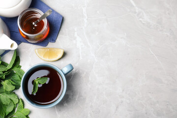 Obraz na płótnie Canvas Fresh tea with mint, honey and lemon on light table, flat lay. Space for text