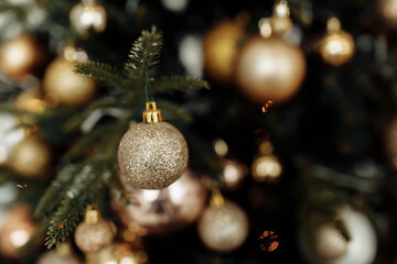 Close up of ball on Christmas tree with decoration and garland, under which a lot of presents. Prepare to winter holidays, New Year background concept
